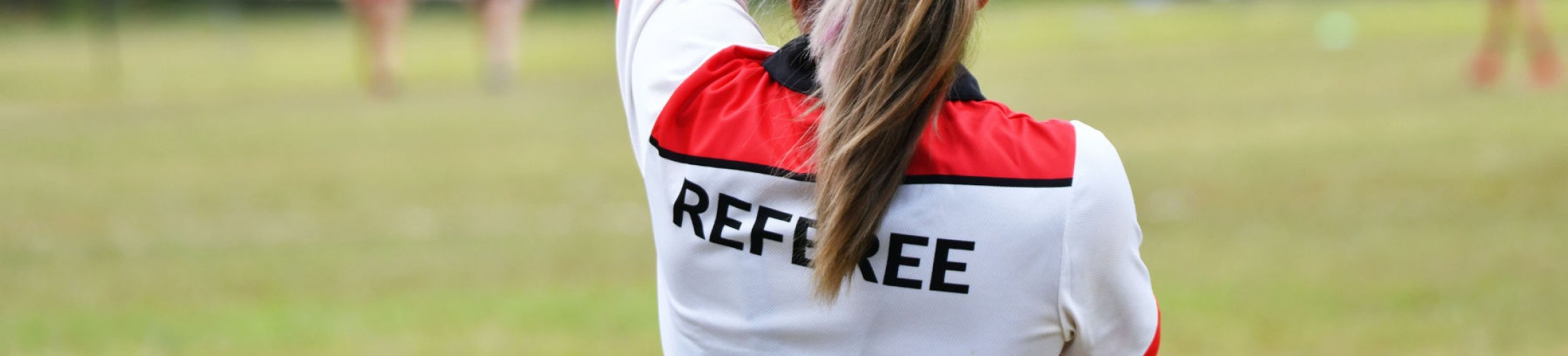 Female ref holds up a red card.
